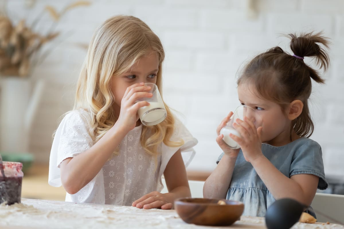 Kinder trinken aus einem Milchglas